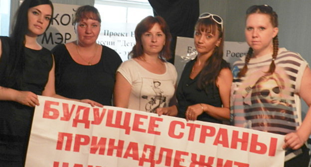 Participants of the protest hunger strike Olga Cheburakova, Ekaterina Romashkina, Tatiana Sviridova, Yulia Yamnova, Irina Kharkova with a poster: "Country's Future Belongs to Children!" Volgograd, May 31, 2013. Photo by Tatiana Filimonova for the "Caucasian Knot"