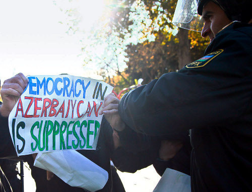 A police officer tries to take away a poster saying "Democracy in Azerbaijan is surpressed" from a protestor. Baku, 2012. Photo by Aziz Karimov for the "Caucasian Knot".