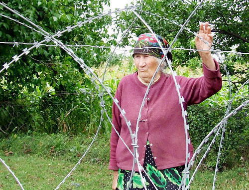 Valya Vanishvili near barbed wire which separated her house from the rest ones. Village Didi Khurvaleti of Gori District, Georgia, July, 2013. Photo by Edita Badasyan for the "Caucasian Knot"