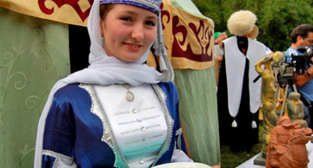 Girl in a traditional costume at the Karachay-Cherkessia cuisine exhibition presented at the youth forum of the North-Caucasian Federal District "Mashuk-2012". Pyatigorsk, July 10, 2013. Photo: official site of the head of the republic, http://www.kchr.ru/