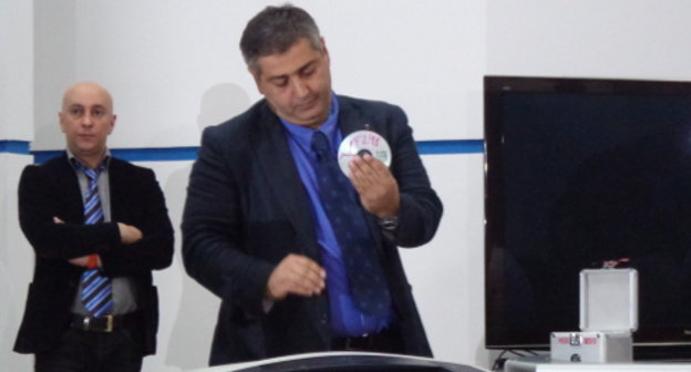 Member of the Ministry of Internal Affairs (MIA) of Georgia destroys a CD with the files of the archive about the personal lives of citizens in a shredder. Tbilisi, September 5, 2013. Photo by Inna Kukudzhanova for the "Caucasian Knot"