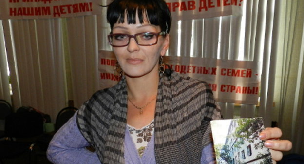 Marina Chernova, participant of the hunger strike organized by parents of many children, shows a photograph of the dilapidated dormitory where she lives with seven children. Volgograd, September 26, 2013. Photo by Tatyana Filimonova for the "Caucasian Knot"