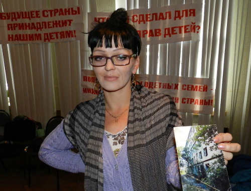 Marina Chernova, participant of the hunger strike organized by parents of many children, shows a photograph of the dilapidated dormitory where she lives with seven children. Volgograd, September 26, 2013. Photo by Tatyana Filimonova for the "Caucasian Knot"