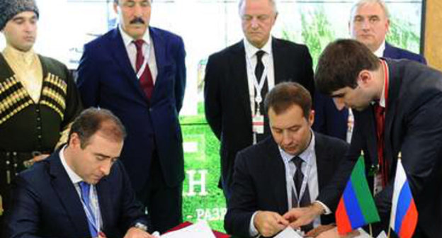 Deputy prime minister of Dagestan Abusupyan Kharkharov (to the left) and deputy chairman of "Russian Bank for Support of Small and Medium Enterprises" management Dmitry Golovanov sign an agreement on cooperation. International investment Forum "Sochi-2013", September 28, 2013. Photo by the press service of the president of Dagestan