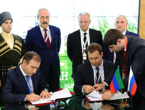 Deputy prime minister of Dagestan Abusupyan Kharkharov (to the left) and deputy chairman of "Russian Bank for Support of Small and Medium Enterprises" management Dmitry Golovanov sign an agreement on cooperation. International investment Forum "Sochi-2013", September 28, 2013. Photo by the press service of the president of Dagestan