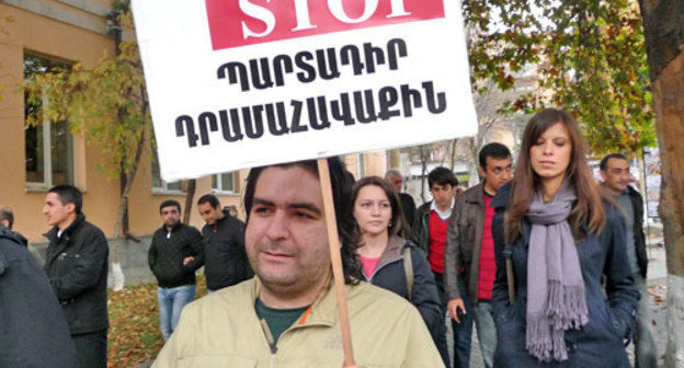 The protesters demanded from the Armenian authorities to correct their pension reform. On the photo is one of the protesters holding poster saying ‘STOP to mandatory taxes’. Yerevan, November 15, 2013. Photo by Armine Martirosyan for the ‘Caucasian Knot’. 