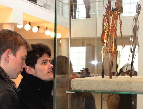 Visitors of the exhibition "Magic of Patterns" near the showcase with puppets from Indonesian shadow theatre "Vayang". Adygea, Maikop, North-Caucasian branch of the State Museum of East, December 6, 2013. Photo by Nikolay Gnedov for the "Caucasian Knot"