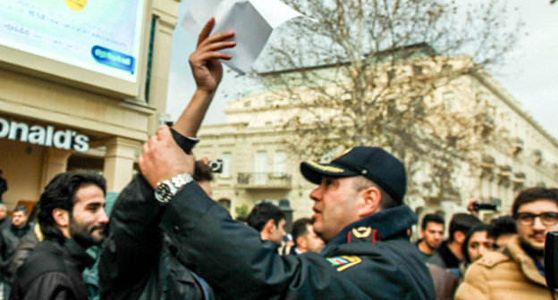 Baku, The Fountain Square, December 8, 2013. The policeman trying to prevent a silent protest against rise in fuel prices. Photo by Aziz Karimov for the ‘Caucasian Knot’. 