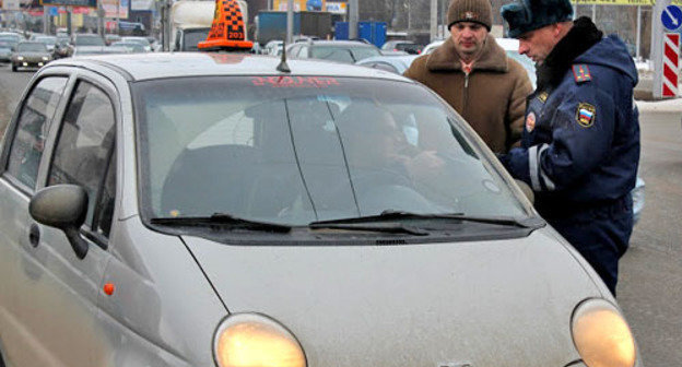 Ф policeman of the separate battalion of the road-and-patrol service checks the documents of a taxi driver on the streets of Stavropol. Photo: http://fedpress.ru/