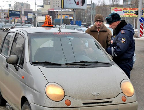 Ф policeman of the separate battalion of the road-and-patrol service checks the documents of a taxi driver on the streets of Stavropol. Photo: http://fedpress.ru/