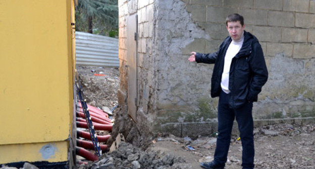 Alexei Baranov, a member of the House Committee of No. 66 in Gagarin Street, shows that sewage runoff has flooded old electric power station and is beginning to flood a new one, and no measures are taken. Sochi, December 11, 2014. Photo by Svetlana Kravchenko for the "Caucasian Knot"