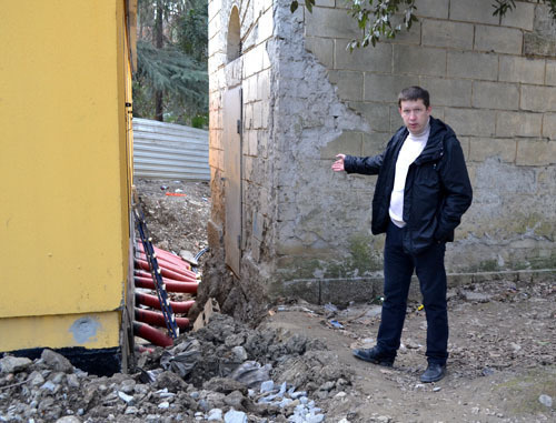 Alexei Baranov, a member of the House Committee of No. 66 in Gagarin Street, shows that sewage runoff has flooded old electric power station and is beginning to flood a new one, and no measures are taken. Sochi, December 11, 2014. Photo by Svetlana Kravchenko for the "Caucasian Knot"