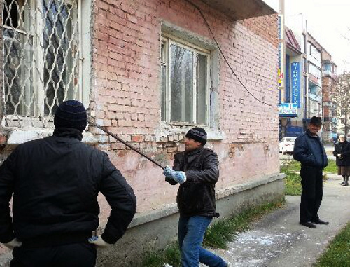 The demolition of a house in Rabochaya Street has started before the eviction of the tenants. In the photo: worker breaks out window security bars on the first floor. Ingushetia, Karabulak, November 19-20, 2013. Photo courtesy of the tenants of No. 21 house in Rabochaya Street