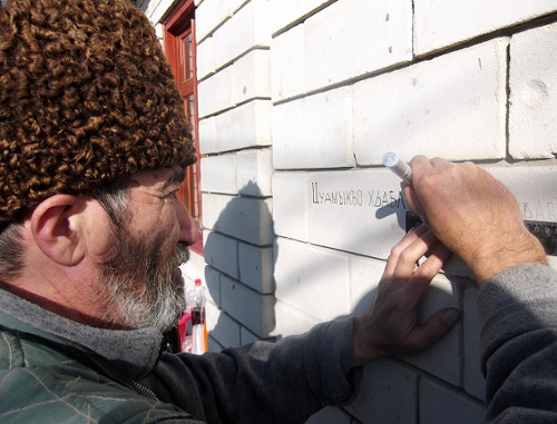 Member of "Adyge Khase-Circassian Council" Sergey Koblev is writing on the wall of his house the names of the villages destroyed during the Caucasian War. Adygea, Maikop, January 2014. Photo: http://www.natpress.ru