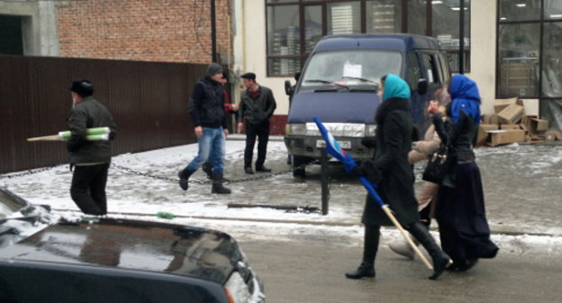 Grozny residents go away with folded flags after the celebrations on the arrival of the Olympic Torch Relay. January 28, 2014. Photo by the "Caucasian Knot"