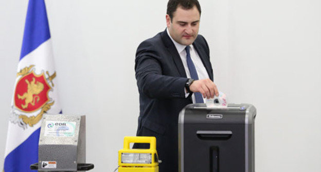 The Minister of Internal Affairs (MIA) of Georgia Alexander Chikaidze destroys a CD with the files of the archive about the personal lives of citizens in a shredder. Tbilisi, September 5, 2013. Photo by the press service of the MIA of Georgia