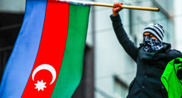 Participant of the rally in protest of fuel prices rise holding the flag of  Azerbaijan. Baku, December 15, 2013. Photo by Aziz Karimov for the ‘Caucasian Knot’. 