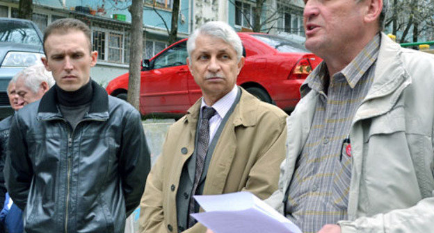 Igor Vasiliev, assistant of Sergey Obukhov, an MP of the Russian State Duma (to the right), takes a petition signed by the sitizens who gathered at the meeting, to hand it over to the State Duma. Sochi, March 2, 2014. Photo by Svetlana Kravchenko for the "Caucasian Knot"