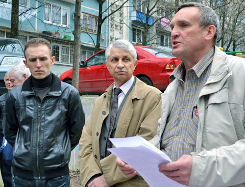 Igor Vasiliev, assistant of Sergey Obukhov, an MP of the Russian State Duma (to the right), takes a petition signed by the sitizens who gathered at the meeting, to hand it over to the State Duma. Sochi, March 2, 2014. Photo by Svetlana Kravchenko for the "Caucasian Knot"