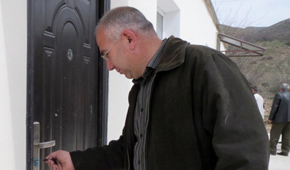 Resettler from Syria Sepukh Sanusyan opens the door of his new flat. The community of Ishkhanadzor, Kashatag District of Nagorno-Karabakh, March 25, 2014. Photo by Alvard Grigoryan for the "Caucasian Knot"