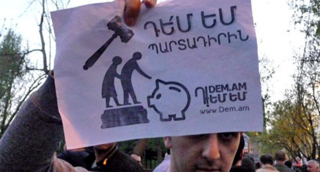 Participant of the action against the pension reform holds a poster "I'm against the mandatory component". Yerevan, April 18, 2014. Photo by Armine Martirosyan for the "Caucasian Knot"