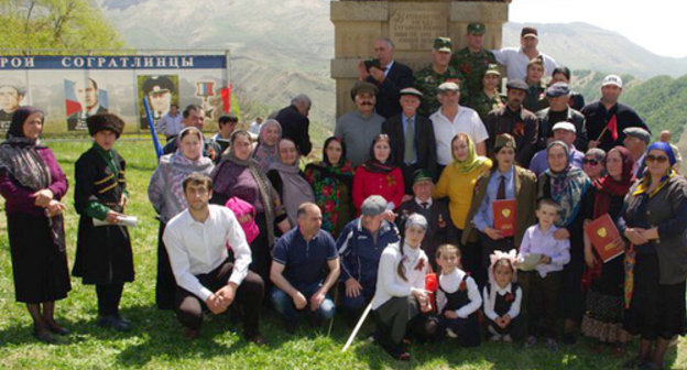 Residents of the village of Sogratl take photo on the Victory day near the monument to the soldiers of the Great Patriotic War damaged by the explosion the day before. May 9, 2014. Photo http://sovet.sogratl.net/