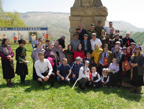 Residents of the village of Sogratl take photo on the Victory day near the monument to the soldiers of the Great Patriotic War damaged by the explosion the day before. May 9, 2014. Photo http://sovet.sogratl.net/