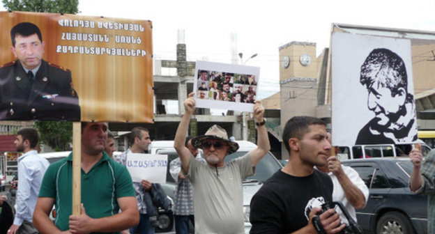 Participants of the action in support of Shant Arutyunyan and other arrested activists of "Million Mask March" carry posters in support of arrested of Volodya Avetisyan, a Karabakh War veteran, with the inscription "Armenia without political prisoners", and of Shant Arutyunyan with the inscription "Freedom to the political prisoners". Yerevan, June 12, 2014. Photo by Armine Martirosyan for the "Caucasian Knot"