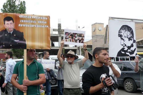 Participants of the action in support of Shant Arutyunyan and other arrested activists of "Million Mask March" carry posters in support of arrested of Volodya Avetisyan, a Karabakh War veteran, with the inscription "Armenia without political prisoners", and of Shant Arutyunyan with the inscription "Freedom to the political prisoners". Yerevan, June 12, 2014. Photo by Armine Martirosyan for the "Caucasian Knot"