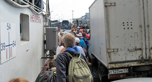 Manoeuvring of the flow of people between small-tonnage vehicles during disembarkation form the ferry. Port "Caucasus", August 2014. Photo by Nina Tumanova for the "Caucasian Knot"