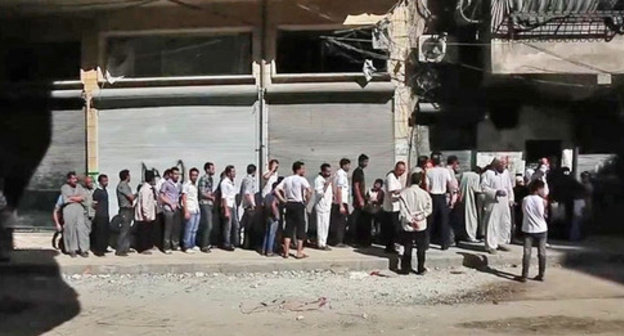 Aleppo residents standing in bread line. Syria. Photo: Voice of America News https://ru.wikipedia.org 