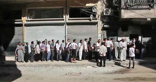 Aleppo residents standing in bread line. Syria. Photo: Voice of America News https://ru.wikipedia.org 