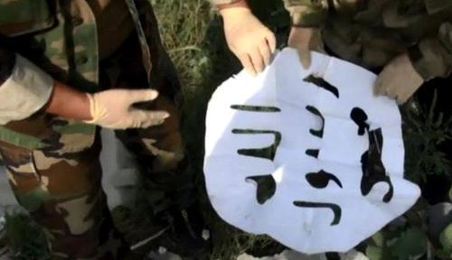 Law enforcers show the militants' flag found at the site of the special operation in the village of Psedakh. August 23, 2017. Photo http://nac.gov.ru