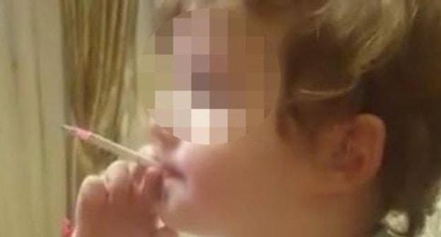 Screenshot of a video with a smoking child. Photo https://www.facebook.com/groups/respublikaalania/permalink/197991943232979