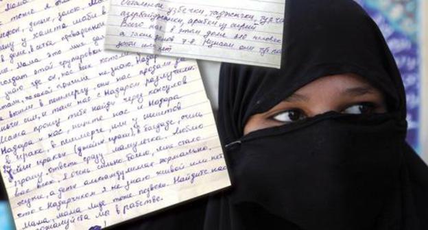 Letters and woman in hijab. Photo: Reuters/Alaa Al-Marjani