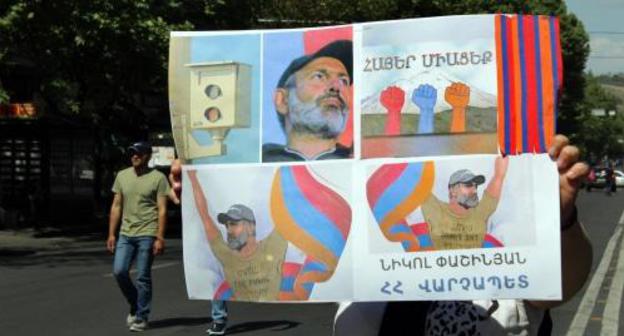 A resident of Yerevan with the posters saying, "Armenians, join us!", "Nikol is the Prime Minister of Armenia". Photo by Tigran Petrosyan for the "Caucasian Knot"