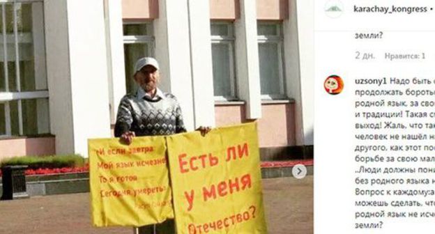 Albert Razin holding posters during a solo picket. Screenshot https://www.instagram.com/p/B2TiGNVgqvI/