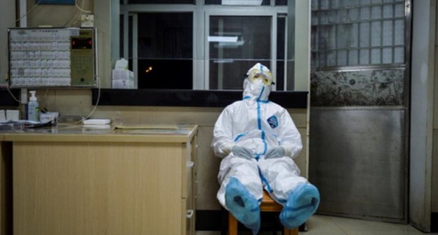 Health worker in a protective suit resting in a hospital in China's Wuhan, February 9, 2020. Photo: China Daily via Reuters