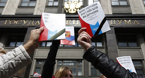 Young people hold the Constitution of Russia near the building of the State Duma. Photo: REUTERS/Sergei Karpukhin
