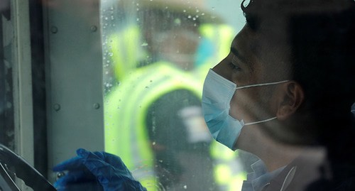 A bus driver wearing medical mask and gloves. USA, March 2020. Photo: REUTERS/Mike Segar