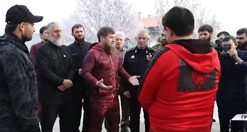 Aslambek Akhmetkhanov (in red) standing in front of Ramzan Kadyrov. Screenshot of the video by the Grozny TV channel "The head of Chechnya harshly reprimanded Aslambek Akhmetkhanov" https://youtu.be/IUHeFy2cpfk