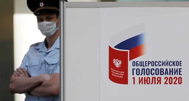 Law enforcer at the poster informing about the voting on amendments to the Constitution of Russia. Photo: REUTERS/Anton Vaganov