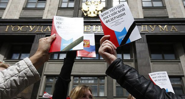 People holding the Constitution of Russia in front of the State Duma building. Photo: REUTERS/Sergei Karpukhin