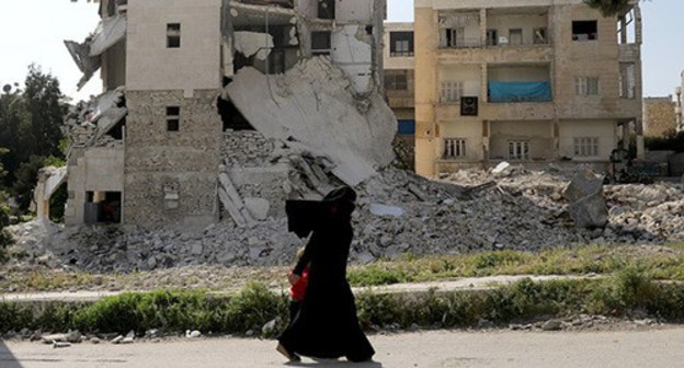 War in Syria. A woman with a child. Photo: REUTERS/Khalil Ashawi