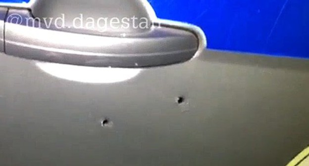 Bullet holes in a side door of the police car. Screenshot from video posted by the press service of the Ministry of Interior for Dagestan, https://05.мвд.рф