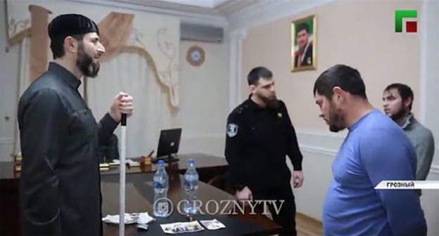 Adam Elzhurkaev, the chief physician of the Centre for Islamic Medicine, scolds the detainees in front of a law enforcer. Screenshot of the video by the "Grozny" TV Channel https://www.instagram.com/p/CI7pCFNJclV/