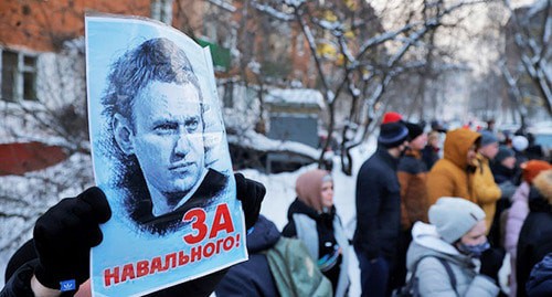 A man holds a poster with the words "For Navalny!"; people standing near the police station where Russian opposition leader Alexei Navalny is being held. Moscow, January 18, 2021. Photo: REUTERS / Maxim Shemetov