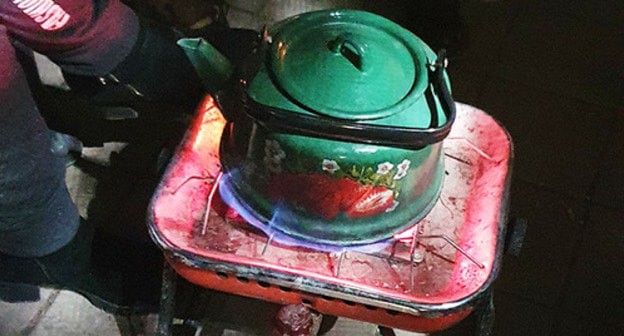 Participants of the protest action warm a kettle on the Theater Square in Tskhinvali, December 15, 2020. Photo by Anna Djioyeva for the "Caucasian Knot"