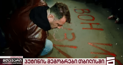 Protester writing on the asphalt: 'Posner, go out of Georgia!' Screenshot: Mtavari Arkhi
