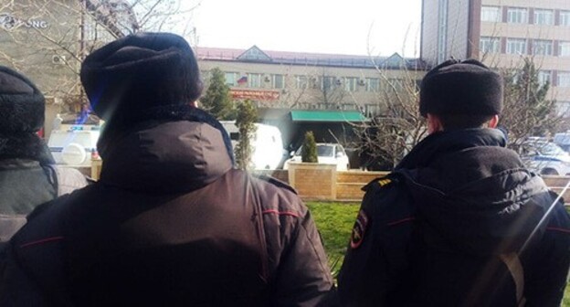 Policemen watching how a car with Ibragim Gadjiev inside is being covered with a canvas, April 2, 2021. Photo by Rasul Magomedov for the Caucasian Knot